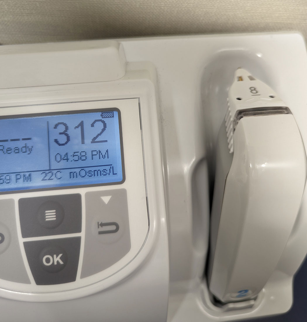 Tear osmolarity unit showing elevated osmolarity reading of 312 mOsm/L.